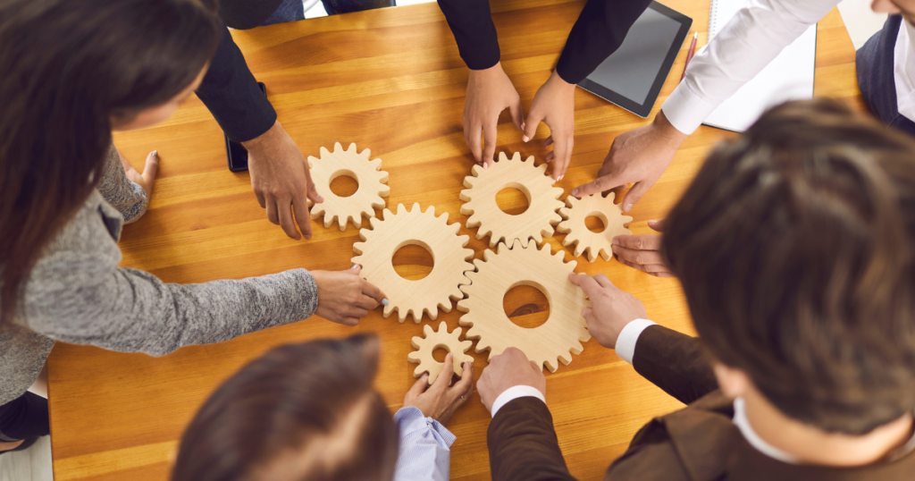 数々の歯車に周りから手を添えるビジネスパーソンたち